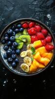 Colorful fruit bowl filled with fresh berries, bananas, mangoes, and kiwis arranged attractively photo