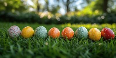 Colorful decorated eggs arranged in a line on lush green grass during a sunny spring day photo