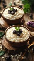 Creamy dessert with blackberries and mint served in wooden bowls on rustic wooden table photo
