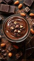 Creamy chocolate mousse topped with nuts and surrounded by chocolate pieces and almonds photo