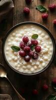Creamy dessert topped with fresh raspberries and mint on a rustic wooden table photo
