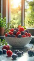 Freshly picked berries arranged in a bowl with vibrant green herbs against a sunlit window backdrop photo