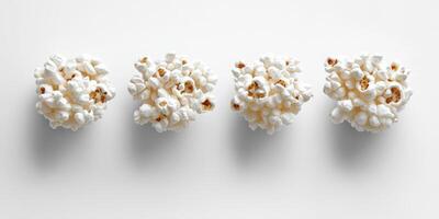 Decorative clusters of popcorn arranged in a neat row on a clean white surface for culinary presentations photo