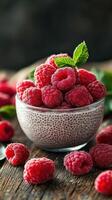 Chia pudding topped with ripe raspberries and mint served on a rustic wooden table photo