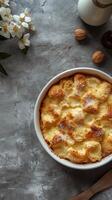 Sweet dessert dish with golden crust served on a textured surface surrounded by decorative elements and ingredients photo