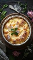 Freshly baked dessert featuring golden crust and creamy filling topped with sugar and mint leaves photo