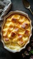 Delicious baked dessert with a golden crust and soft center made from bread and custard served with a silver spoon photo