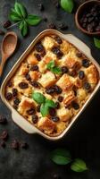 Delicious bread pudding baked with raisins and garnished with fresh mint leaves photo
