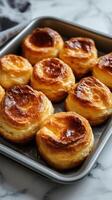 Baked pastries resting on a tray, showcasing golden-brown crusts and flaky texture in a cozy kitchen setting photo