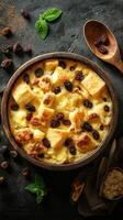 Rich bread pudding with raisins served in a wooden bowl surrounded by spices and mint leaves photo