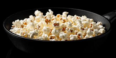 Freshly popped popcorn in a skillet ready for movie night at home photo
