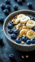Healthy breakfast bowl with chia seeds, banana slices, and blueberries served in a textured bowl photo