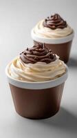 Creamy dessert cups topped with swirls of chocolate and vanilla frosting on elegant light background photo