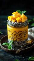 Delicious mango chia pudding served in a jar topped with fresh mango cubes and mint leaves at a cozy kitchen setting photo