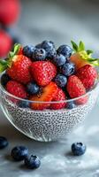 Fresh berries and chia seeds create a colorful and nutritious dessert bowl on a gray table photo