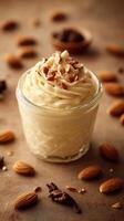Creamy dessert topped with almonds and chocolate pieces on a rustic surface photo