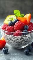 Chia seed pudding topped with fresh berries and mint leaves in a glass bowl photo