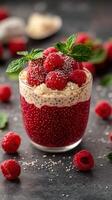 Vibrant raspberry chia pudding served in a glass with fresh mint and a dark background photo