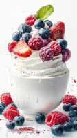Delicious soft serve topped with fresh raspberries, blueberries, and strawberries in a white bowl photo