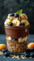 Delicious layered dessert featuring chocolate, fruits, and oats in a clear jar photo