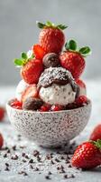 Delicious dessert featuring layers of ice cream topped with strawberries and chocolate sauce in a beautiful bowl photo