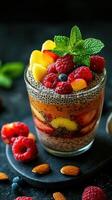 Refreshing chia seed pudding topped with vibrant fruits served in a glass on a dark surface photo