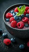Fresh berries and chia seeds create a vibrant and nutritious bowl on a dark surface photo