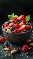 Fresh berries and almonds in a decorative bowl on a dark background photo
