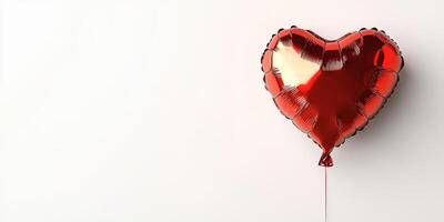 Bright red heart-shaped balloon floats gently against a plain white background for celebration or decoration photo