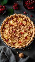 Delicious fruit pie with crumb topping featuring apples and red currants on a dark background photo