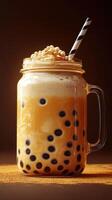 Delicious bubble tea served in a glass mug with tapioca pearls and a striped straw on a dark background photo