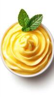 Creamy mango mousse with mint leaves served in a white bowl on a bright background photo
