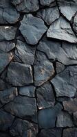 Textured black stones create a striking surface in a natural stone wall under soft lighting photo