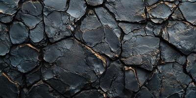 Dark textured surface showcasing cracked and fractured stone patterns under natural light in a close-up view photo