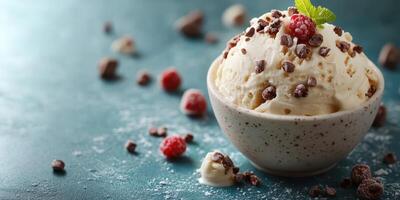 Indulgent bowl of vanilla ice cream topped with chocolate shavings and raspberries on a textured surface photo