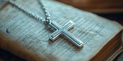 Elegant silver cross resting on an antique book with detailed pages in soft lighting setting ambiance photo
