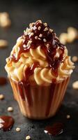 Delicious dessert topped with caramel sauce and chopped nuts on a dark background photo