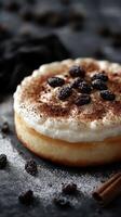 Delicious dessert topped with cream, cocoa powder, and dried fruits on a dark textured surface photo