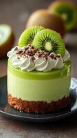 Delicious green mousse cake topped with kiwi slices and chocolate shavings on a dark plate photo