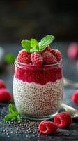 Delicious raspberry chia pudding served in a glass with fresh mint leaves photo
