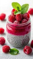 Raspberry chia pudding with fresh fruit garnished on a light surface photo