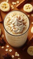 Delicious smoothie topped with cream, oats, and spices on a warm brown surface with banana slices and cinnamon sticks photo