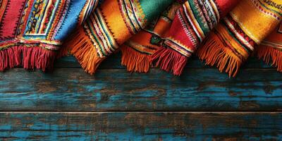 Colorful woven blankets resting on a rustic wooden surface in a cozy indoor setting photo