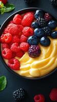 Fresh and colorful fruit bowl with creamy mango base, featuring raspberries and blackberries arranged artfully photo