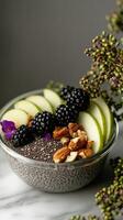 Chia seed bowl topped with blackberries, green apple slices, and almonds, elegantly arranged on a marble surface photo