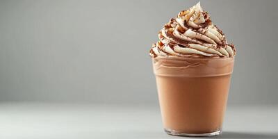 Creamy chocolate dessert topped with whipped cream served in a glass cup against a neutral background photo