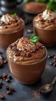Mouthwatering chocolate mousse dessert with whipped cream and coffee beans served in glass cups photo