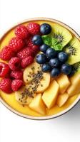 Fresh fruit bowl with vibrant colors featuring raspberries, blueberries, kiwi, and bananas on a white background photo