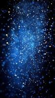 Bright blue particles sparkling in a dark background during a nighttime event photo