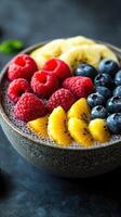 Fresh fruit bowl featuring vibrant raspberries, blueberries, and banana slices on a dark background photo